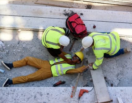 Construction workers assisting an injured colleague on site
